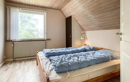 ein großes Bett in einem Zimmer mit Fenster in der Unterkunft Schönes Ferienhaus Auf Bornholm Mit Meerblick in Neksø