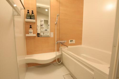 a bathroom with a shower and a tub and a sink at Firmament Shimoshinjo in Osaka
