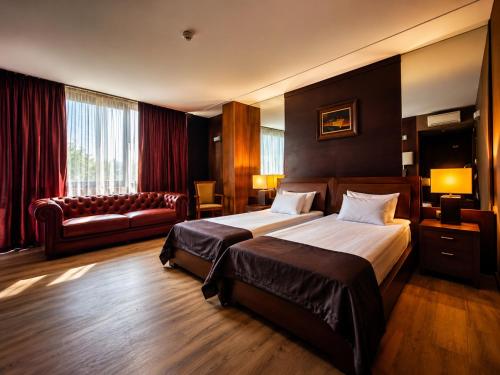 a hotel room with two beds and a couch at Hotel City Pleven in Pleven