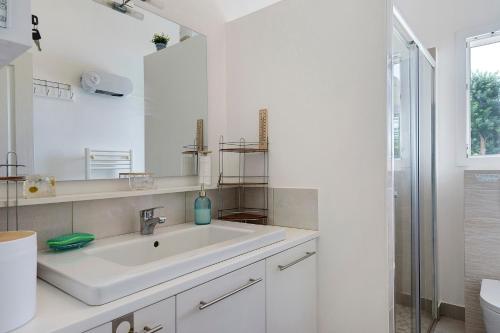 a white bathroom with a sink and a mirror at Le Cocon Taillonais avec piscine in Saint-Ciers-du-Taillon