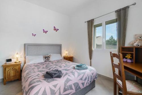 a bedroom with a bed and a desk and a window at Le Cocon Taillonais avec piscine in Saint-Ciers-du-Taillon