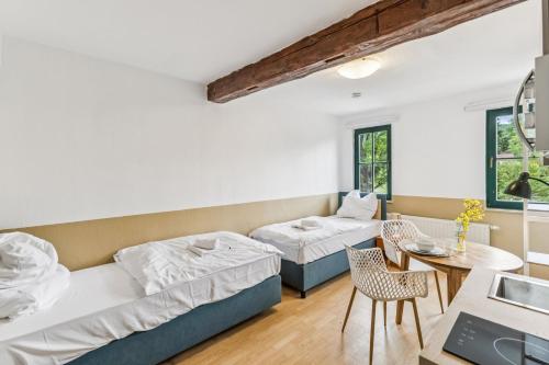 a room with two beds and a table and chairs at Jenapartments Pension - Studios mit Küche in Jena