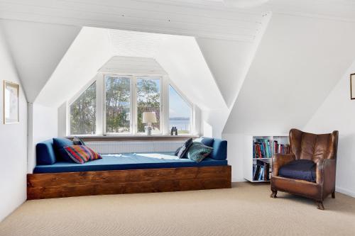 a bedroom with a blue bed and a window at Summerhouse With Both Island Charm And Sea View in Holbæk