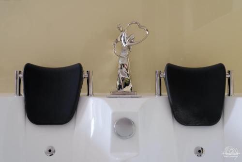 a trophy sitting on top of a sink with two chairs at Le Cocon Love Room & Spa in Nancy