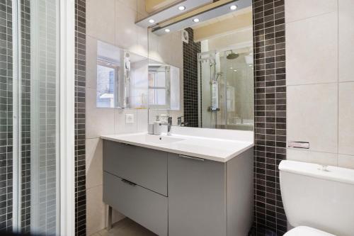 a bathroom with a sink and a toilet and a mirror at Gîte Le Cèdre, sans vis-à-vis in Limeyrat