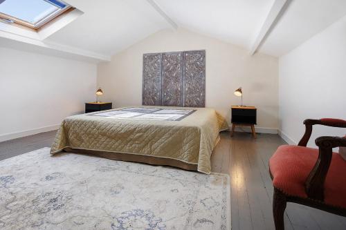 a bedroom with a bed and two tables and a window at Gîte Le Cèdre, sans vis-à-vis in Limeyrat