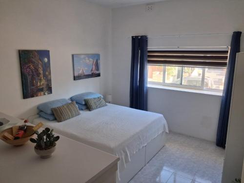 ein weißes Schlafzimmer mit einem Bett und einem Fenster in der Unterkunft 56, Windchimes in Pembroke