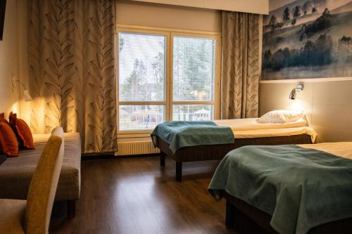 a hotel room with two beds and a window at Tanhuvaaran urheiluopisto & Sport Resort in Savonlinna