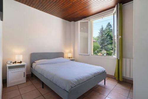 a small bedroom with a bed and a window at La Mailleraie - L'etang in Valojoulx