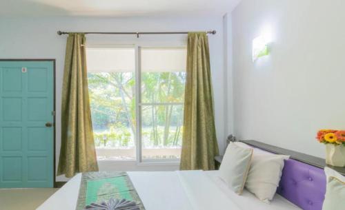 a bedroom with a bed and a large window at Chaiyo Riverfront Resort Phuket in Phuket