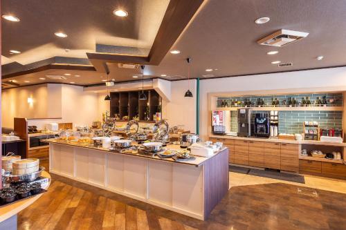 a large kitchen with a buffet in a restaurant at Alpico Plaza Hotel in Matsumoto