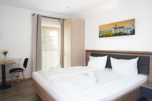 a bedroom with a bed and a desk and a window at Rote Villa Füssen in Füssen