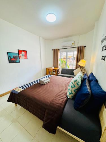 a bedroom with a large bed with blue pillows at Happy Home Samui near Mae Nam beach on main road in Ban Mae Nam