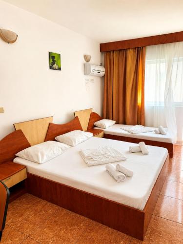 a bedroom with two beds and a window at Vila Flavia in Costinesti