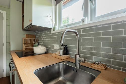 a kitchen with a stainless steel sink and a window at Boshuis Luna | 4 persons in Gasselte