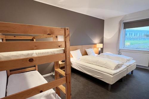 zwei Etagenbetten in einem Zimmer mit Fenster in der Unterkunft Møn Golf Resort - Hotel Præstekilde in Stege