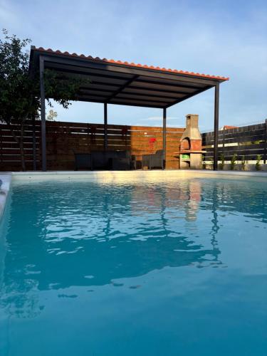 a swimming pool with a pavilion in the background at Villa Green Escape in Dugobabe