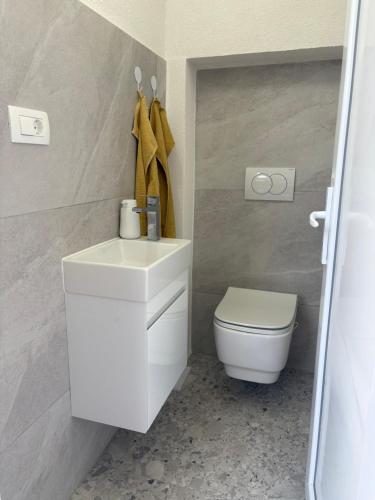 a bathroom with a white sink and a toilet at Villa Green Escape in Dugobabe