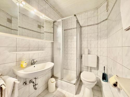 a bathroom with a toilet and a sink and a shower at Midway Weser Hotel Nienburg in Nienburg