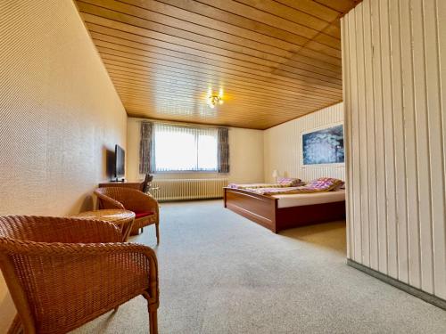 a room with a bed and a desk and chairs at Midway Weser Hotel Nienburg in Nienburg