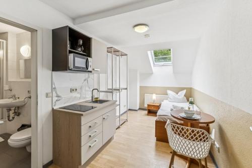 a small kitchen with a sink and a bathroom at Jenapartments Pension - Studios mit Küche in Jena