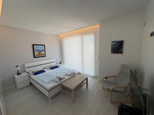 a bedroom with a bed and a table and a chair at Aroeira Villa B&B in Charneca