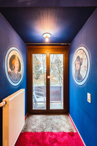 a room with two paintings on the wall and a door at Design Hotel Euskirchen in Euskirchen