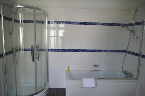 a bathroom with a shower and a tub and a sink at Westhill Country Hotel in Saint Helier Jersey