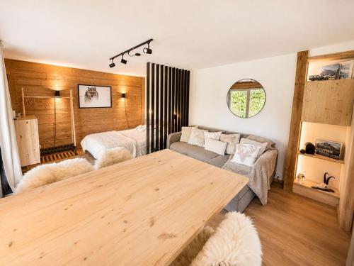 a living room with a wooden table and a couch at L'Aiglon- Piscine Naturelle Privatisable in Salvan