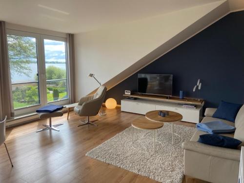 a living room with a couch and a tv at Seepanorama in Groß Wittensee
