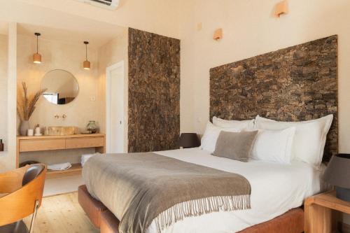 a bedroom with a large bed with a stone wall at A Casa Brava in Santarém