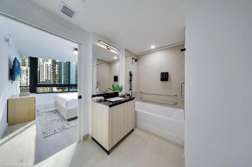 a bathroom with a sink and a bath tub at District 225 Condo by Ionica in Miami