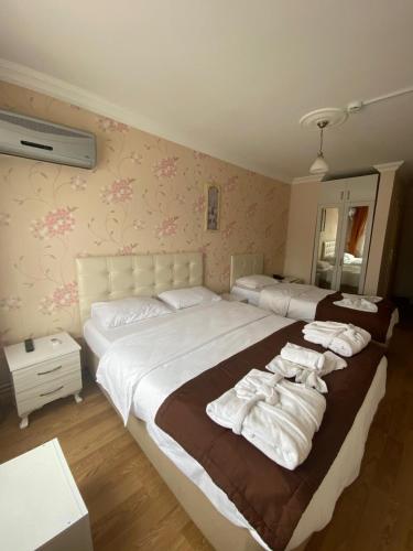 a bedroom with two beds with towels on them at Kiraz Otel in Lapseki