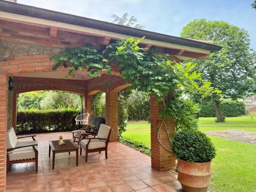 a pavilion with chairs and tables on a patio at Villa Las tres Mares 6826 in Noja