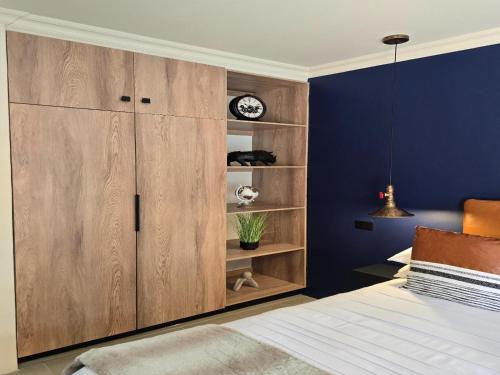 a bedroom with a large wooden cabinet and a bed at NiNETEEN28 Guesthouse in Pietermaritzburg