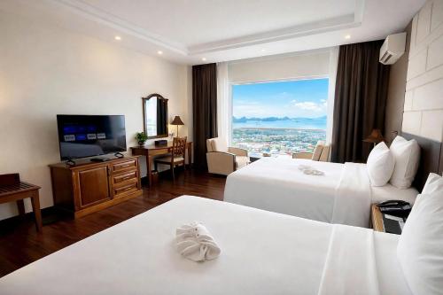 a hotel room with two beds and a television at Sai Gon Ha Long Hotel in Ha Long