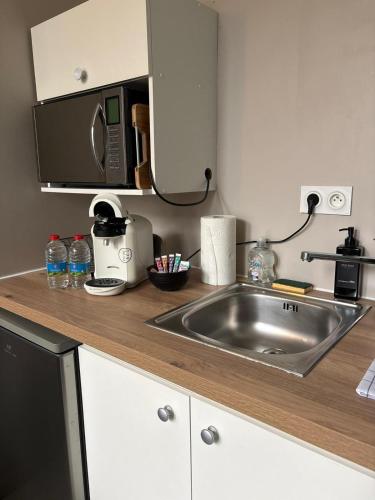 a kitchen with a sink and a microwave at Le Moderne - 2 Voyageurs in Rouen