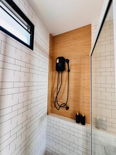 a bathroom with a shower with white tiles at Meena boutique in Ban Nai Wat