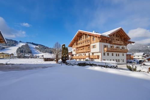 a building in the snow in front of a mountain at Rainerhof in Flachau