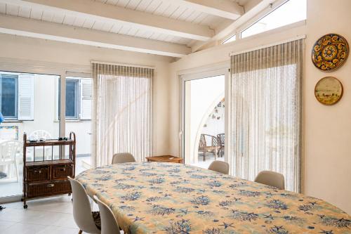 a dining room with a large table and chairs at Puntabraccetto Sunset in Santa Croce Camerina