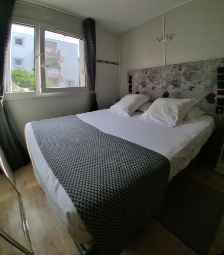 a bedroom with a large white bed with a window at Les Lavandins,Chambre climatisé, à 300 Tram L5, PARKING et WIFI gratuit in Montpellier