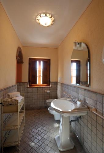 a bathroom with a sink and a toilet and a mirror at Molino del Rotone in Buti