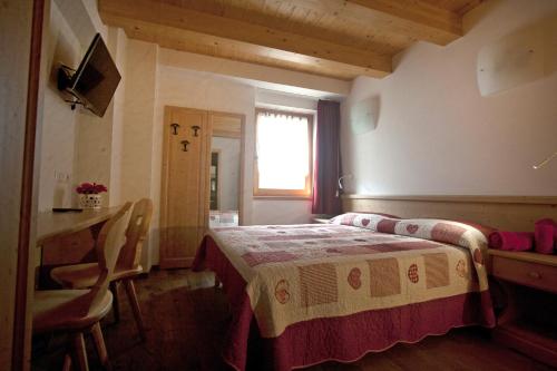 1 dormitorio con cama, mesa y ventana en Agricampeggio Ai Gaggi, en Pellizzano