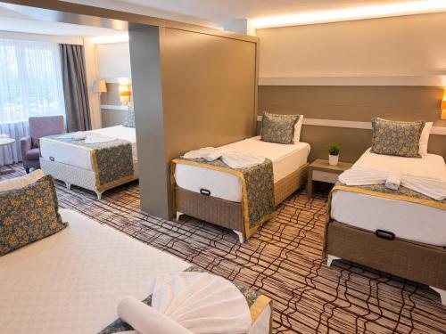 a hotel room with two beds and a mirror at Burcman Hotel in Bursa