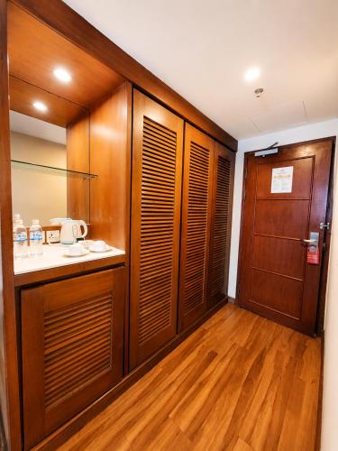 a bathroom with wooden cabinets and a sink and a mirror at Sabah Oriental Hotel in Kota Kinabalu