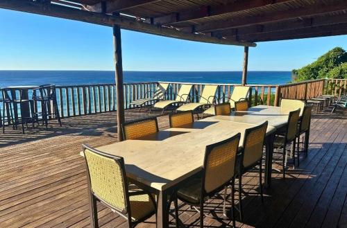 a wooden deck with a table and chairs and the ocean at Kangela 1 in Ponta Malangane