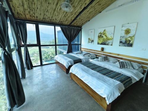 two beds in a room with large windows at Mây Villa HA in Yên Bài