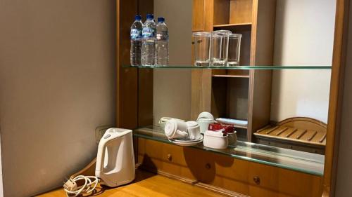 ein Badezimmer mit Ablagefläche, Toilette und Wasserflaschen in der Unterkunft Kresna Hotel in Wonosobo