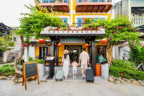 a family standing in front of a building at Yzistel Hoi An in Hoi An