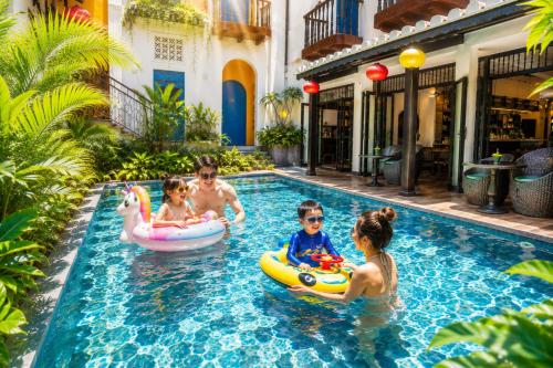 a group of people playing in a swimming pool at Yzistel Hoi An in Hoi An
